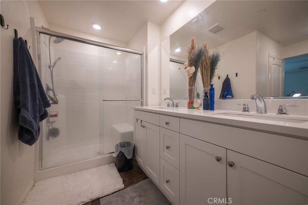 1099 Little Leaf Street Calimesa, CA 92320 - Photo 14 of 32 a bathroom with a double vanity sink a toilet and a mirror