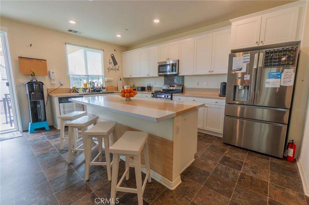 1099 Little Leaf Street Calimesa, CA 92320 - Photo 5 of 32 a kitchen with stainless steel appliances a refrigerator a stove a sink dishwasher and a refrigerator with wooden floor