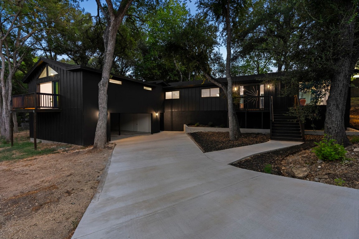 a front view of a house with a yard and tree s