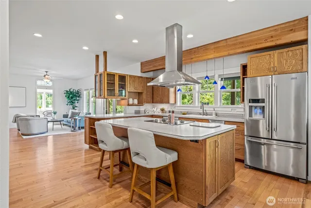 a kitchen with stainless steel appliances a dining table chairs stove and refrigerator