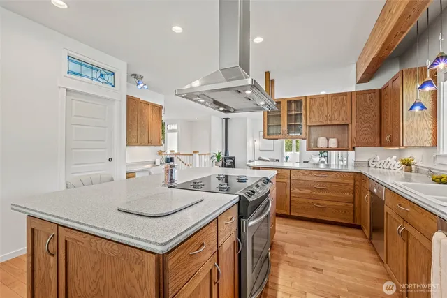 a kitchen with stainless steel appliances granite countertop a sink a stove and a refrigerator