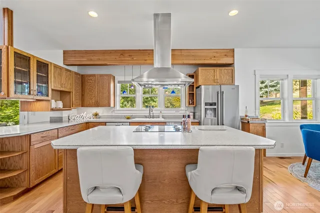 a kitchen with stainless steel appliances a dining table chairs and wooden floor
