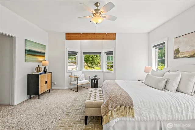 a bedroom with a bed and a chandelier fan