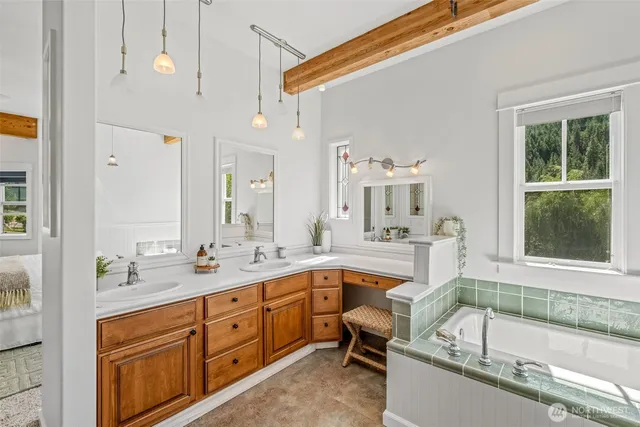 a bathroom with a granite countertop sink mirror and bathtub