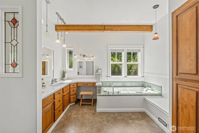 a spacious bathroom with a tub sink and mirror