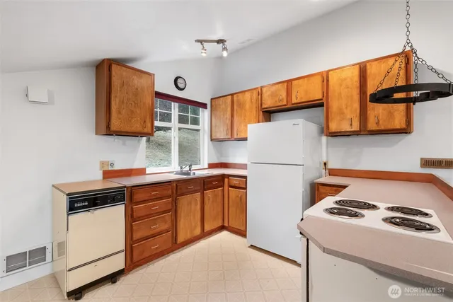 a kitchen with stainless steel appliances granite countertop a refrigerator and a sink