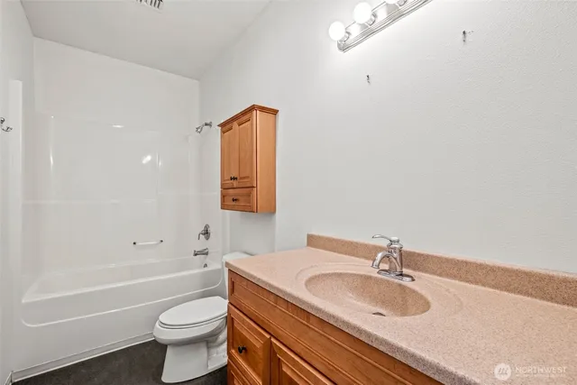 a bathroom with a granite countertop sink a toilet and bathtub