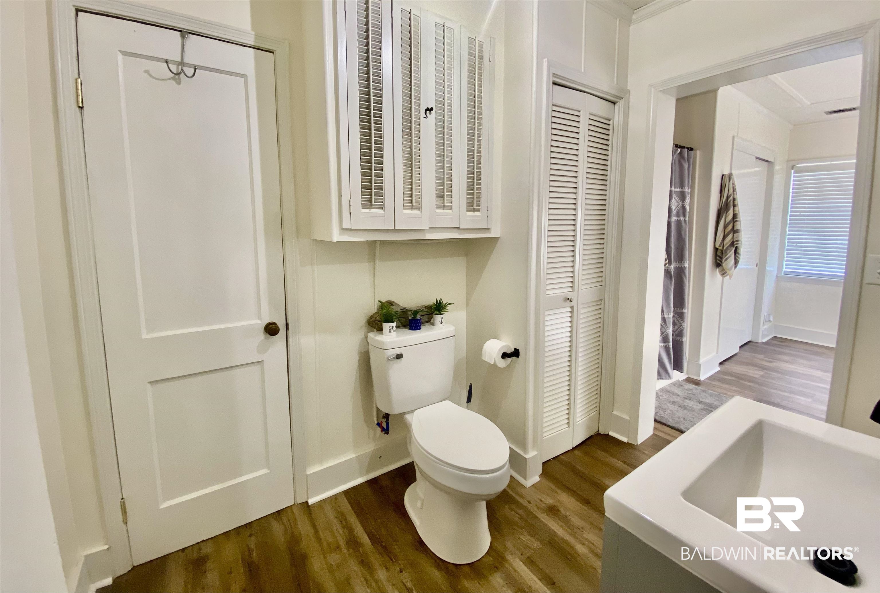 531 Highway 136 Monroeville, AL 36460 - Photo 28 of 48 Bathroom with toilet, hardwood / wood-style floors, sink, and ornamental molding