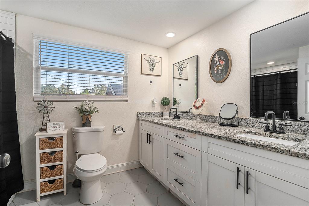 4921 6th Street Zephyrhills, FL 33542 - Photo 13 of 15 a bathroom with a granite countertop toilet sink and mirror