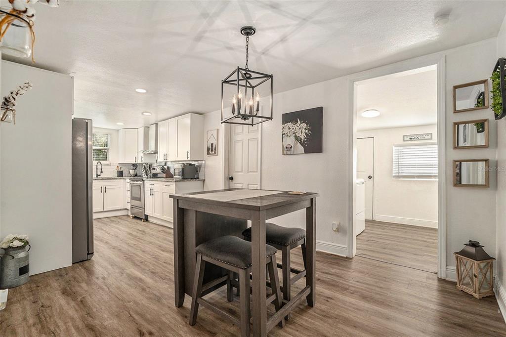 4921 6th Street Zephyrhills, FL 33542 - Photo 7 of 15 a kitchen with stainless steel appliances a dining table chairs refrigerator and microwave
