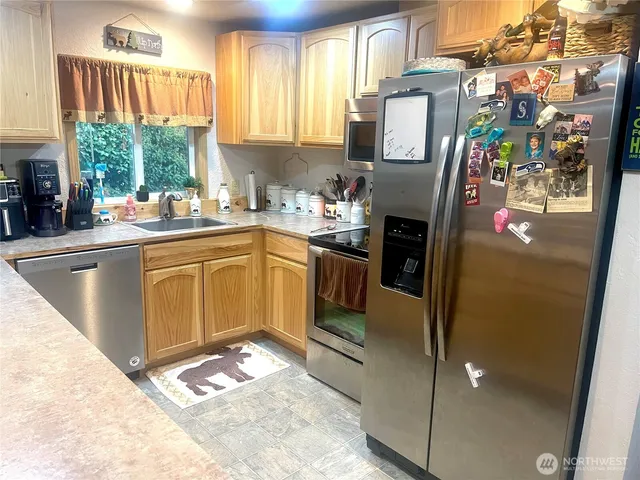 a kitchen with stainless steel appliances granite countertop a refrigerator sink and cabinets