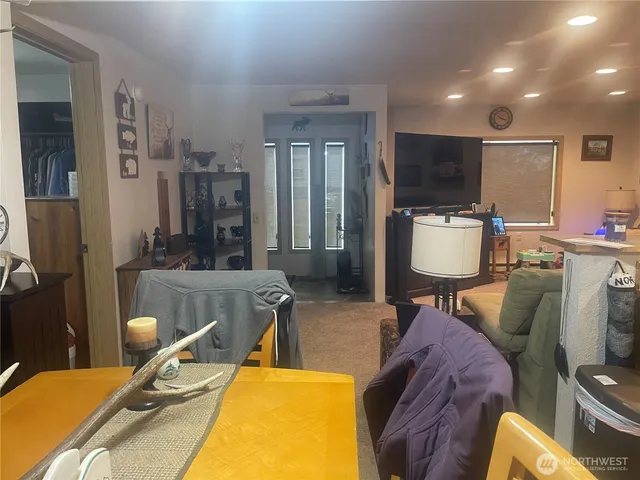 a living room with furniture a flat screen tv and kitchen view