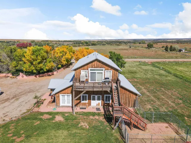a view of a big house with a big yard and large trees