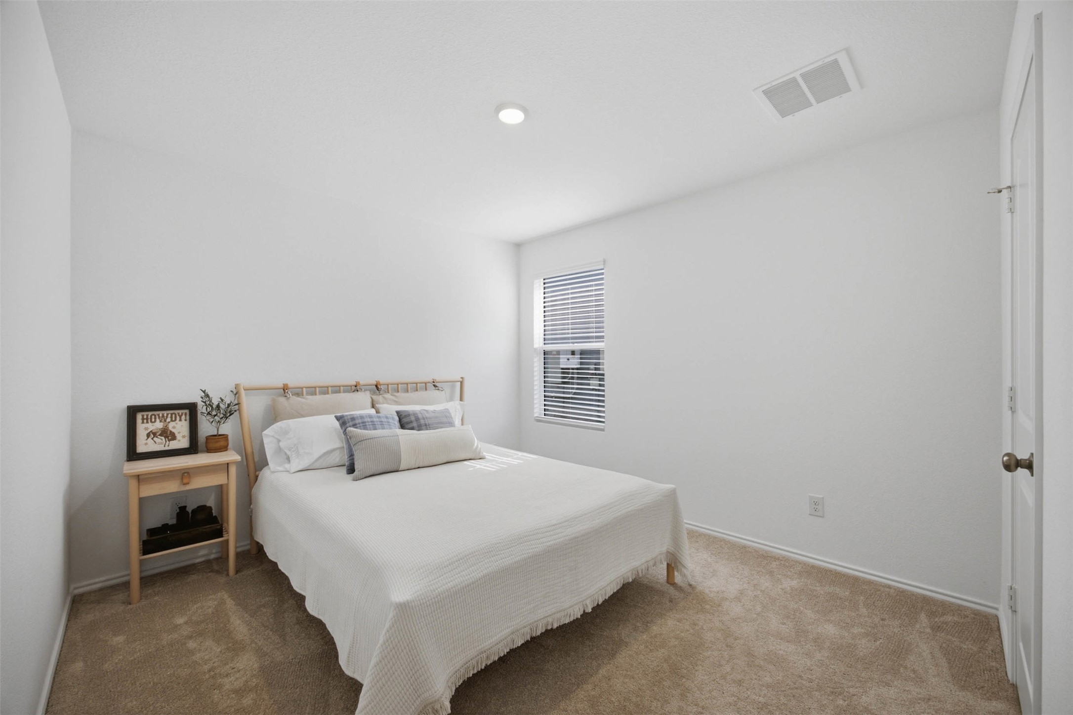 171 Cattle Queen Road Jarrell, TX 76537 - Photo 17 of 38 A window brings natural light into this serene bedroom featuring wall-to-wall carpeting.