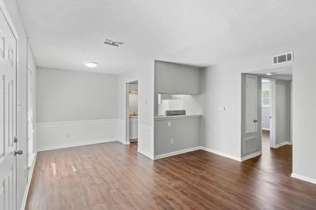 a view of empty room with wooden floor