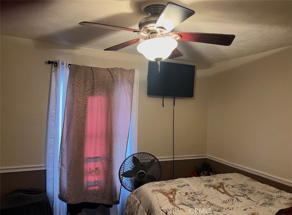 904 Riverside Avenue Chowchilla, CA 93610 - Photo 6 of 6 a bedroom with a bed and a chandelier