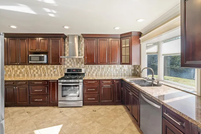 a kitchen with stainless steel appliances granite countertop a stove sink and cabinets