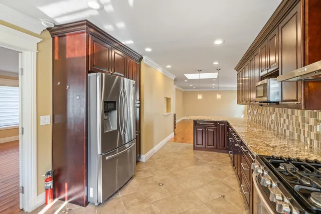a kitchen with stainless steel appliances granite countertop a refrigerator and a stove