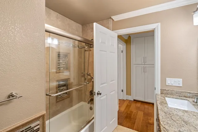 a bathroom with a granite countertop sink a mirror and a shower