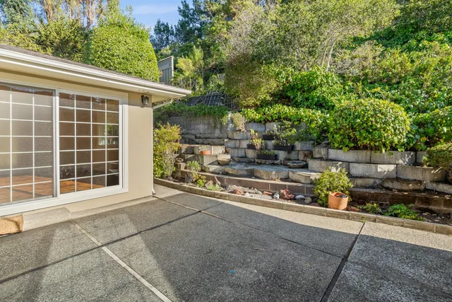 an aerial view of a house with a yard and seating space