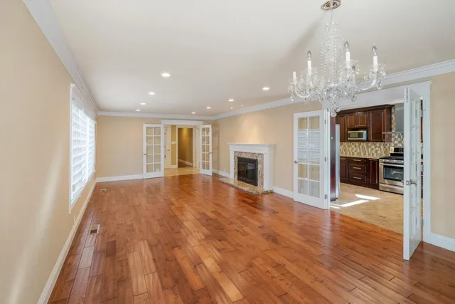 a view of empty room with wooden floor and fireplace