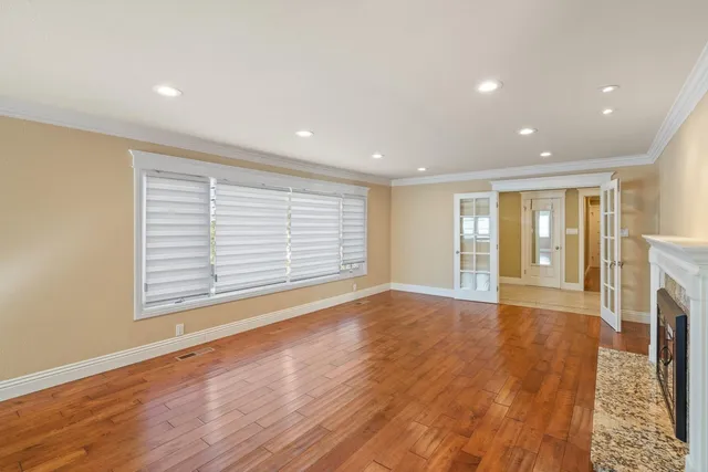 a view of empty room with wooden floor and fireplace