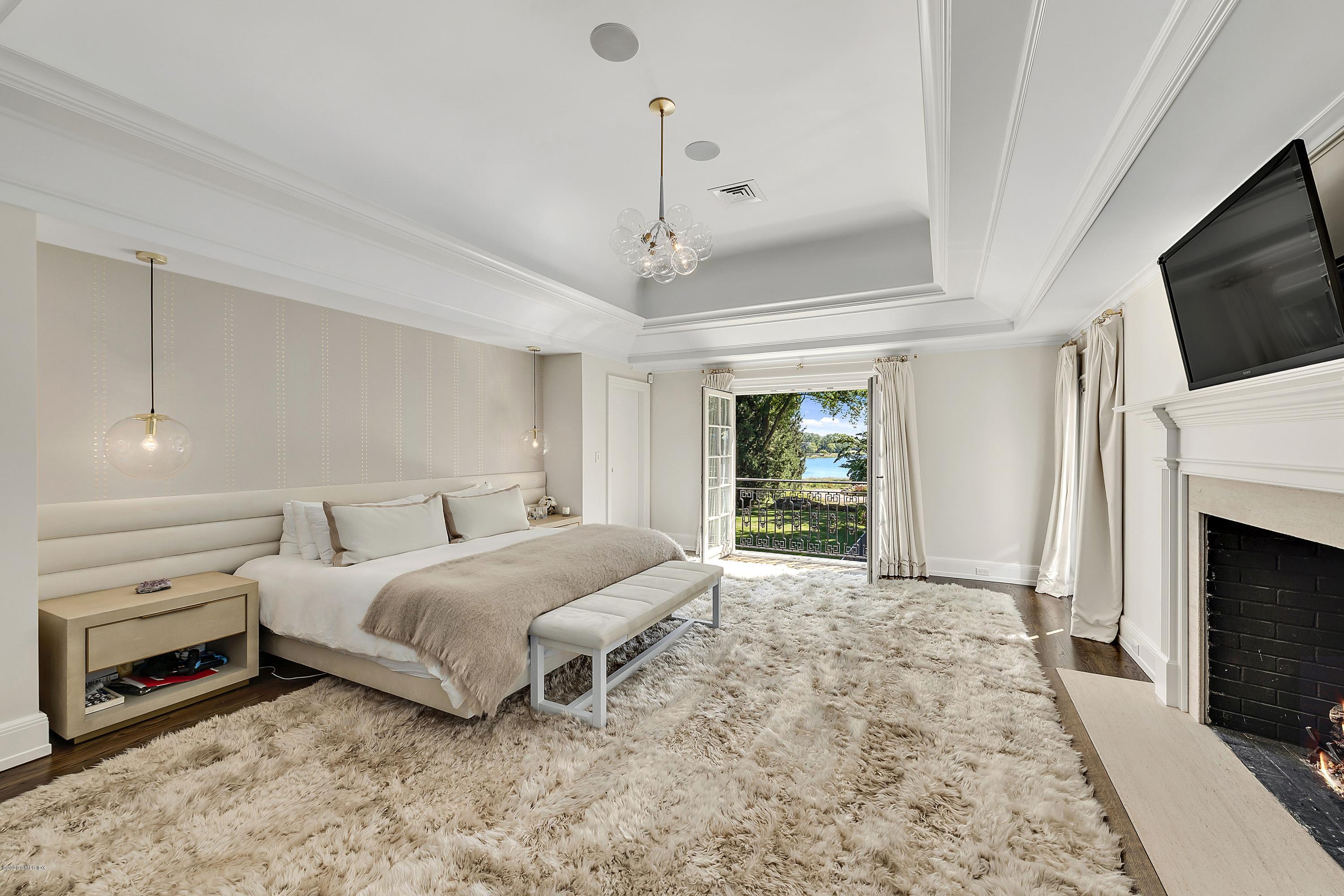 16 Chimney Corner Lane Greenwich, CT 06830 - Photo 24 of 39 a spacious bedroom with a bed and a flat screen tv