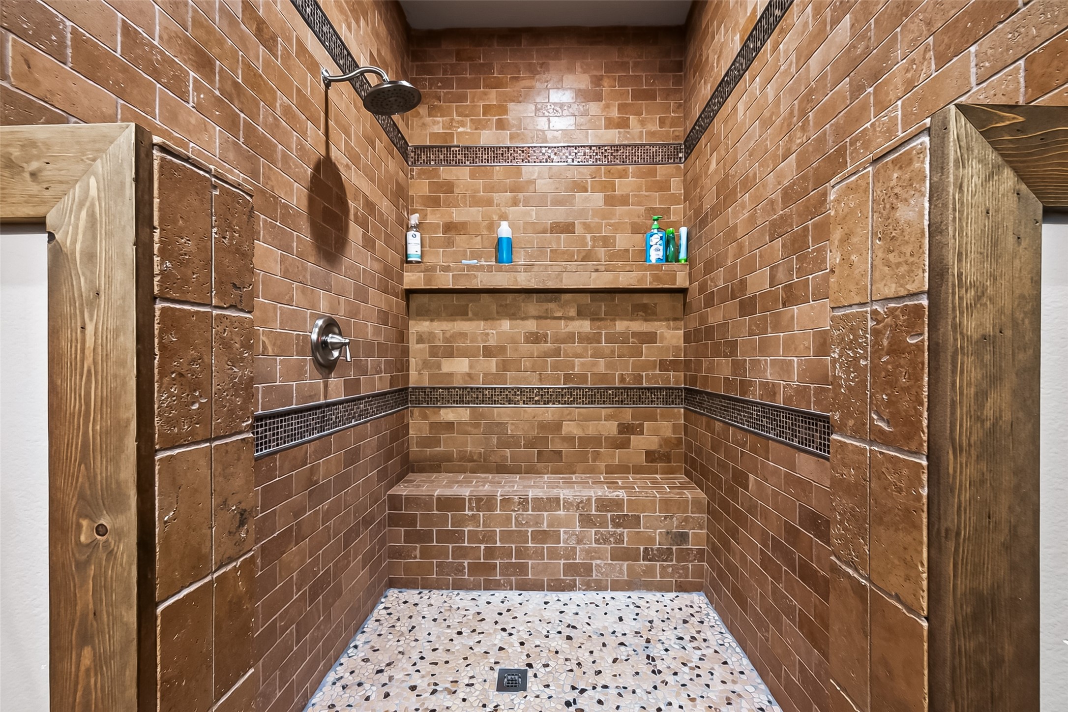 22610 Cessna Road Needville, TX 77461 - Photo 25 of 37 Step into a spacious, elegantly tiled walk-in shower featuring natural stone and a convenient built-in bench.