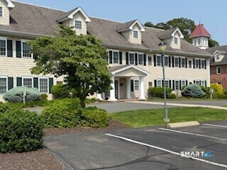 a view of a white house with a big yard and large trees