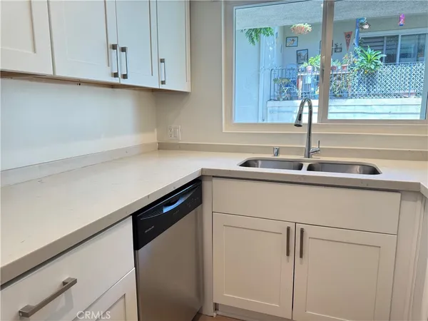 a kitchen with granite countertop white cabinets and a sink