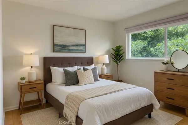 a bedroom with a bed and a lamp on dresser