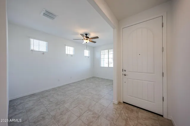 an empty room with chandelier fan