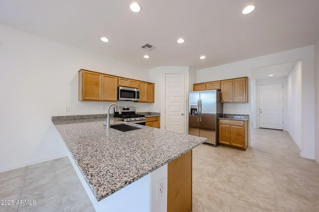 a kitchen with sink refrigerator and microwave