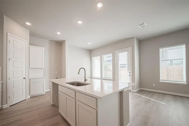 a kitchen with kitchen island a sink appliances and cabinets