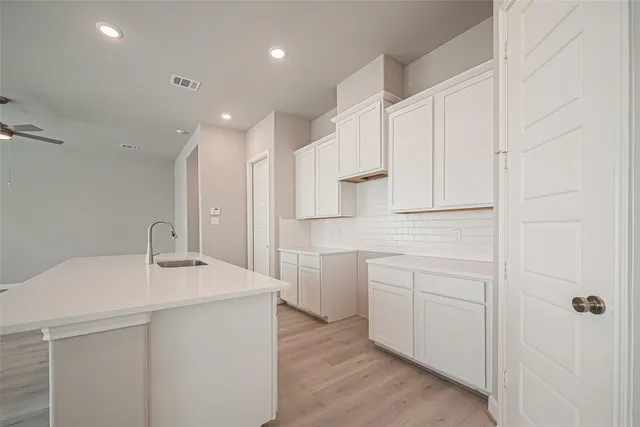 a kitchen with white cabinets appliances and sink