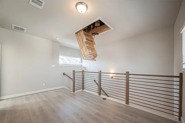 a view of a room with wooden floor and white walls