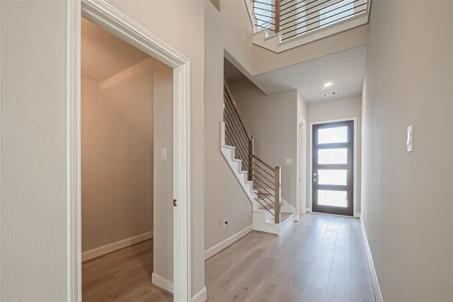 a view of a hallway with wooden floor and staircase