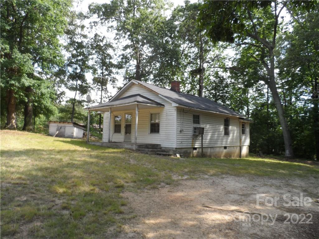 a front view of house with yard and trees all around