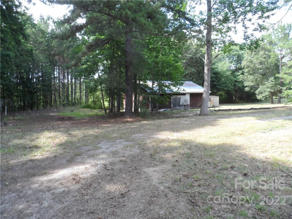 1184 Wilma Sigmon Road Lincolnton, NC 28092 - Photo 3 of 15 a view of a yard with large trees and a small barn