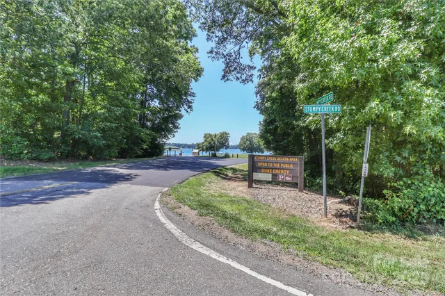 a backyard of a house with lots of plants and large trees