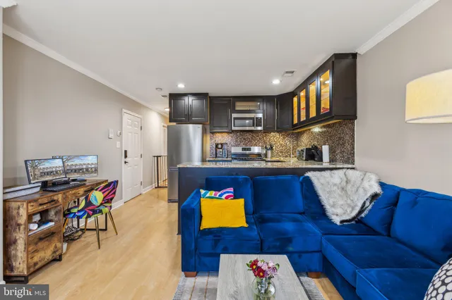 a living room with furniture and a kitchen area