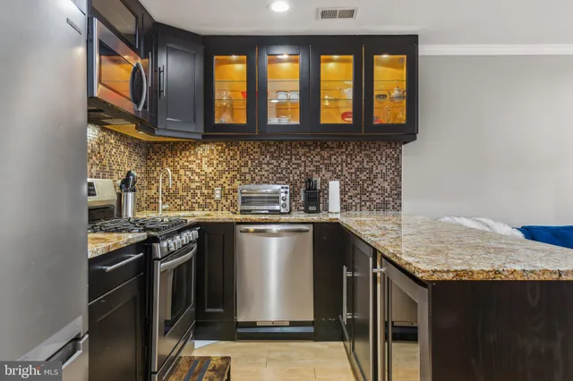 a kitchen with stainless steel appliances granite countertop a sink stove and microwave