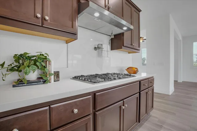 a view of a kitchen with a sink and dishwasher a refrigerator with wooden floor