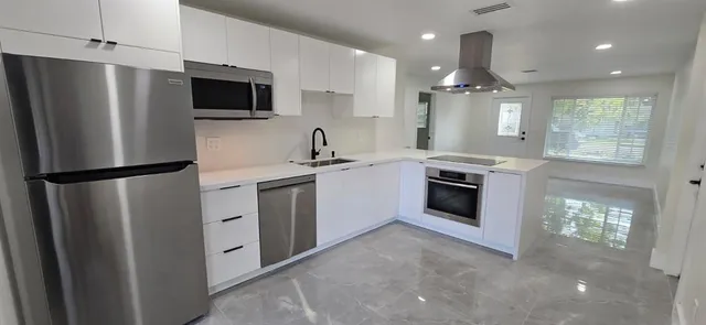 a kitchen with stainless steel appliances a refrigerator sink and microwave