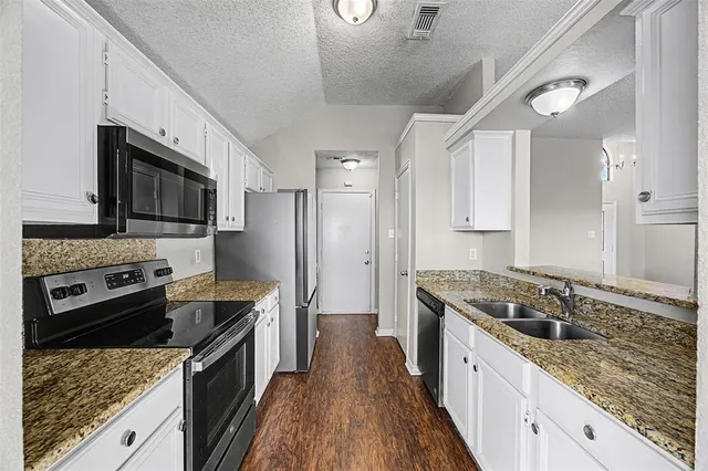 a dining room with wooden floor a chandelier a glass table and chairs