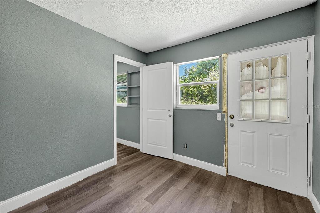 1257 North Pine Hills Road Orlando, FL 32808 - Photo 13 of 35 an empty room with wooden floor cabinet and windows