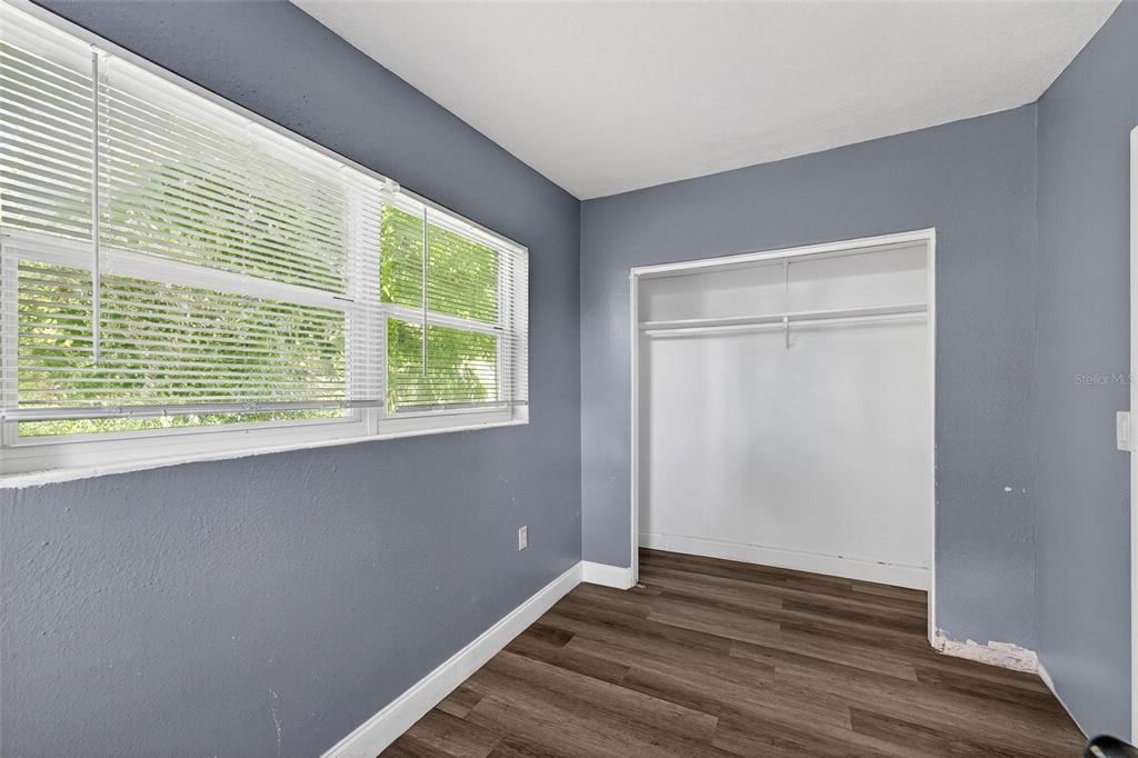 1257 North Pine Hills Road Orlando, FL 32808 - Photo 17 of 35 a view of an empty room with wooden floor and a window
