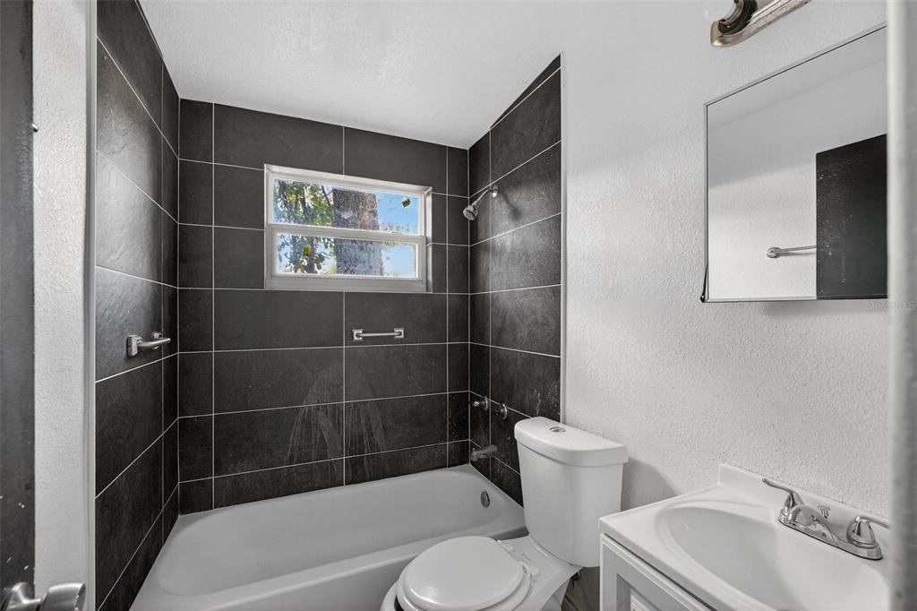 1257 North Pine Hills Road Orlando, FL 32808 - Photo 18 of 35 a bathroom with a toilet a sink and bathtub