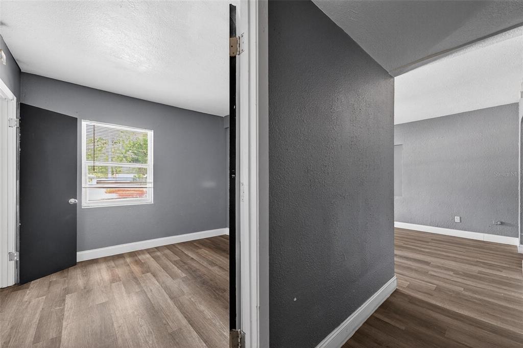 1257 North Pine Hills Road Orlando, FL 32808 - Photo 22 of 35 an empty room with wooden floor and windows