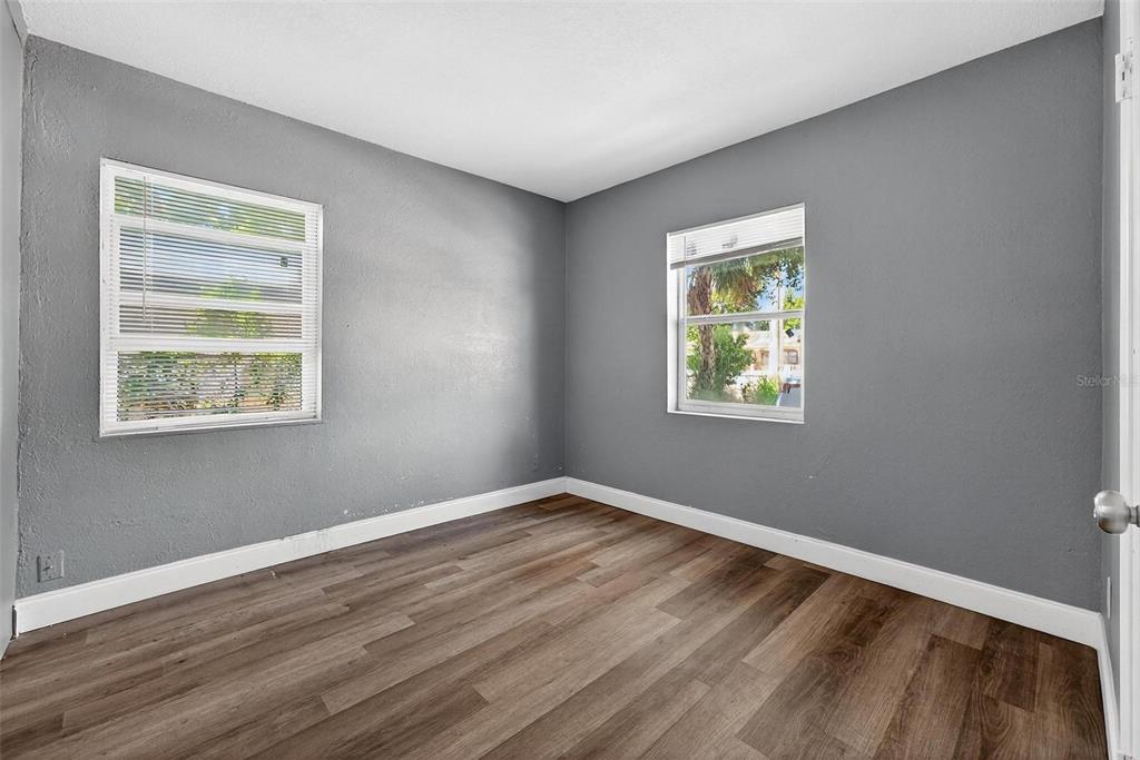1257 North Pine Hills Road Orlando, FL 32808 - Photo 25 of 35 a view of an empty room with wooden floor and a window